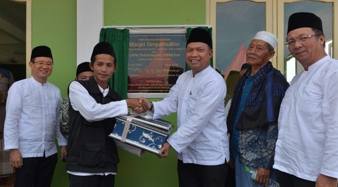 Ketua Umum GAPKI Joko Supriyono (ketiga dari kanan) menyerahkan bantuan secara simbolis kepada pengurus Masjid Sirojuttholibin. Foto : GAPKI