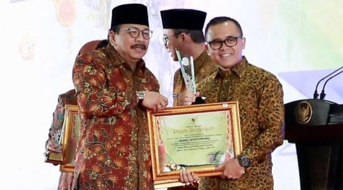 Bupati Banyuwangi Abdullah Azwar Anas (kanan) menerima penghargaan yang diserahkan langsung oleh Gubernur Jawa Timur Soekarwo. Foto : Tribunnews.com