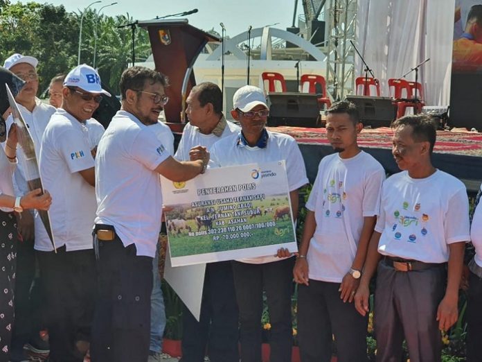Menteri Pertanian Syahrul Yasin Limpo menyerahkan polis asuransi kepada petani sebagai wujud wujud dukungan pemerintah di sektor pertanian. Foto: Kementan