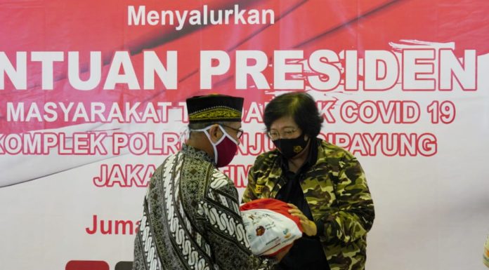 Menteri Lingkungan Hidup dan Kehutanan Siti Nurbaya menyerahkan bantuan presiden Joko Widodo, berupa paket sembako di keluarga besar purnawirawan TNI-Polri di Mujul, Cipayung. Foto: Istimewa